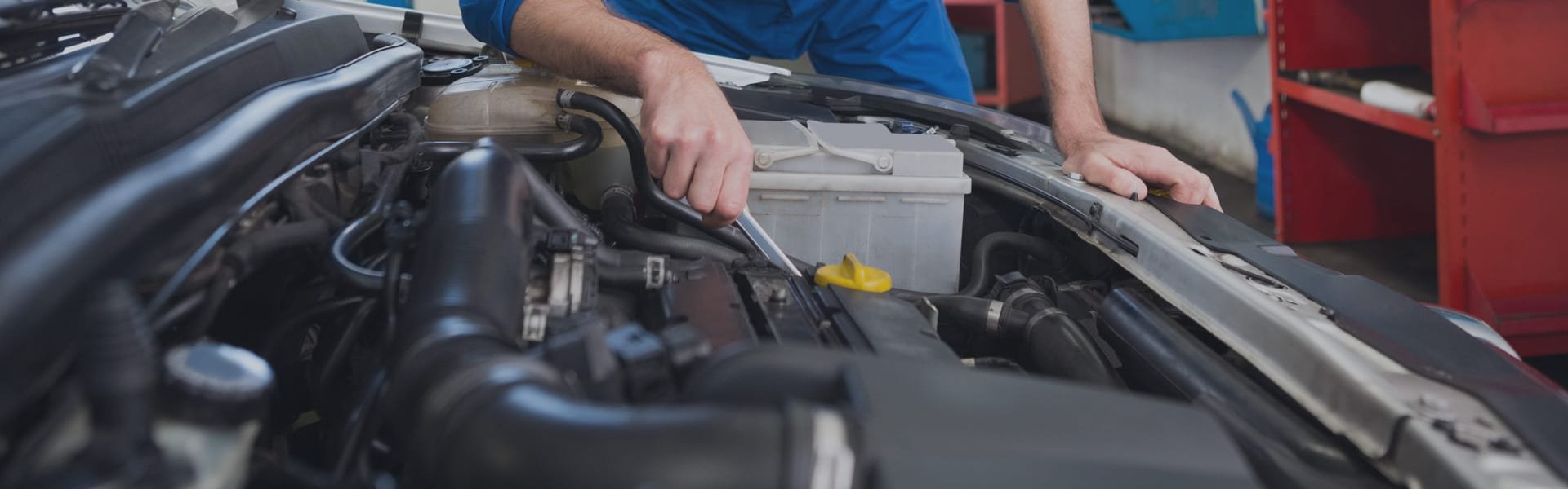 Mechanic working in a car engine bay during a repair