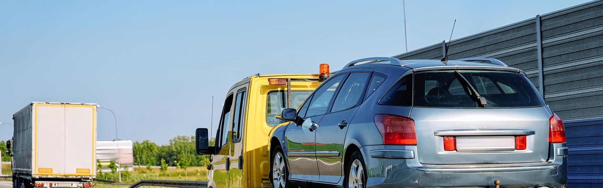 Tow truck recovering a broken-down car for roadside assistance